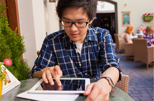 A young man scrolling on a tablet